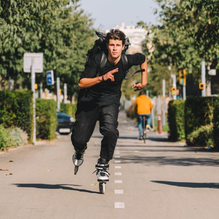 El niño está jugando los patines y usando el casco.